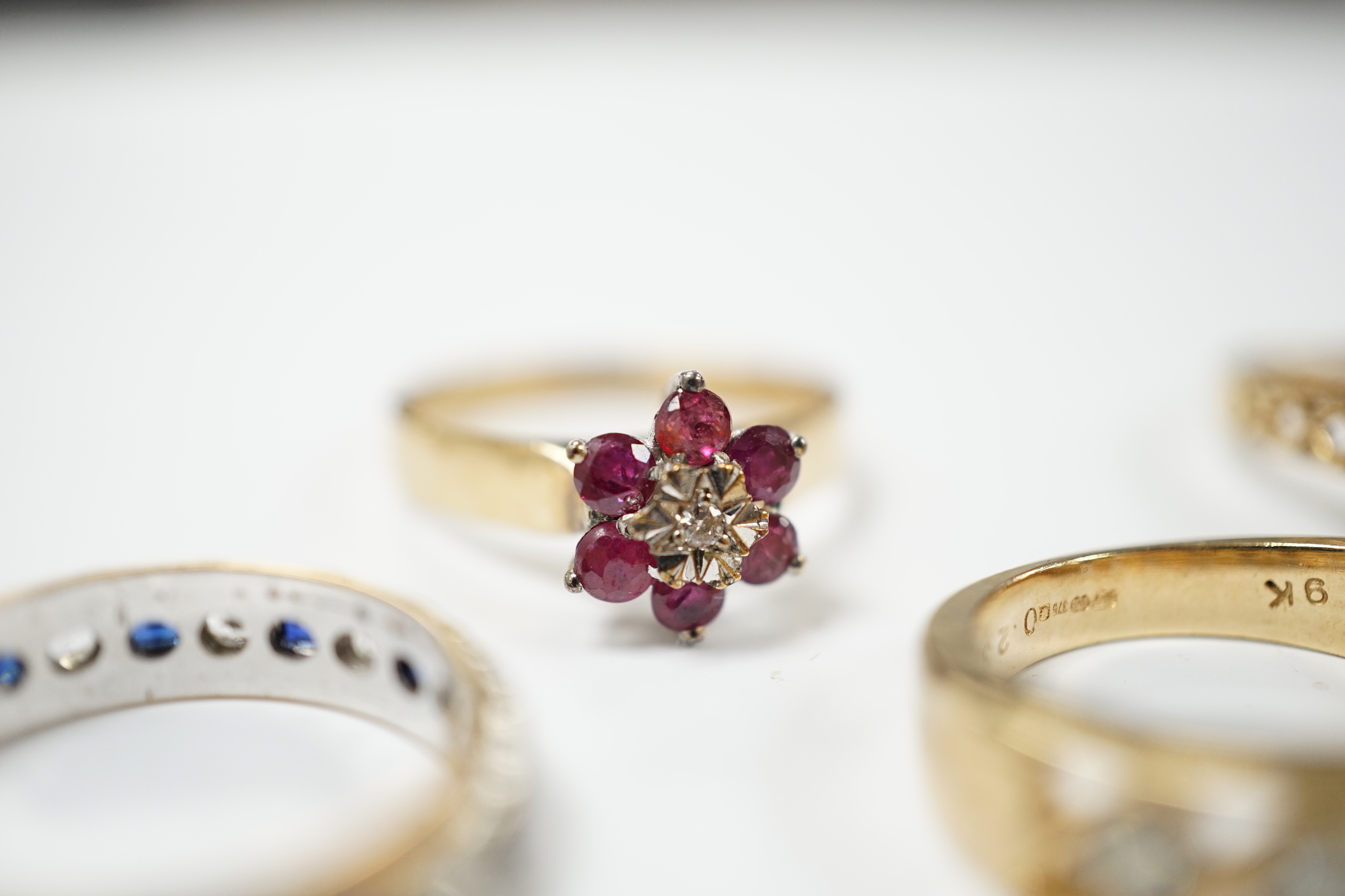 Five assorted modern 9ct gold and gem set dress rings including ruby and diamond cluster and six stone diamond set half hoop, gross weight 14.4 grams.